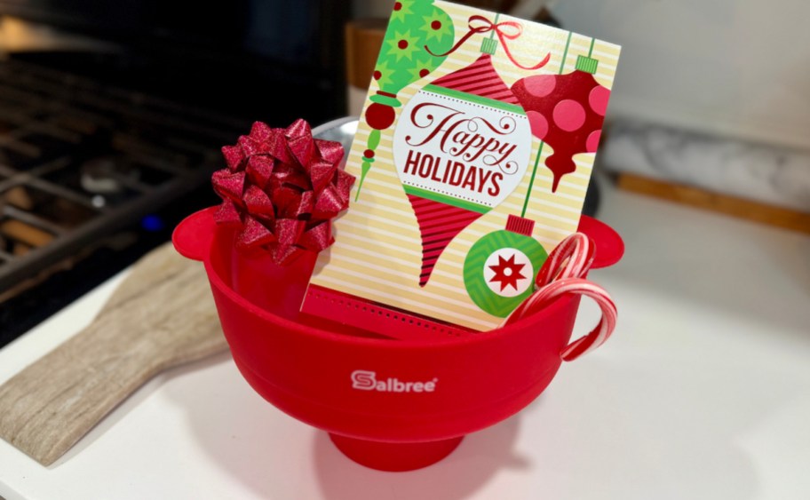 red popcorn maker on kitchen counter with holiday card and bow