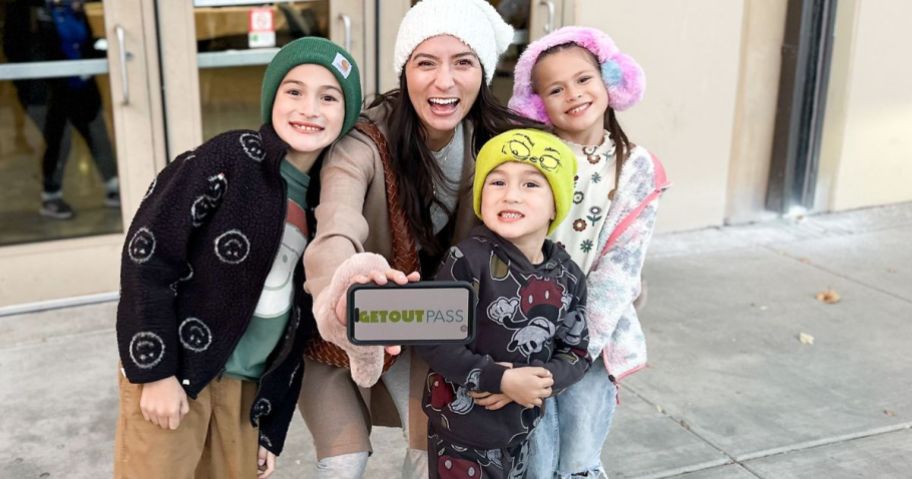 Woman with 3 kids holding up a GetOutPass on her phone