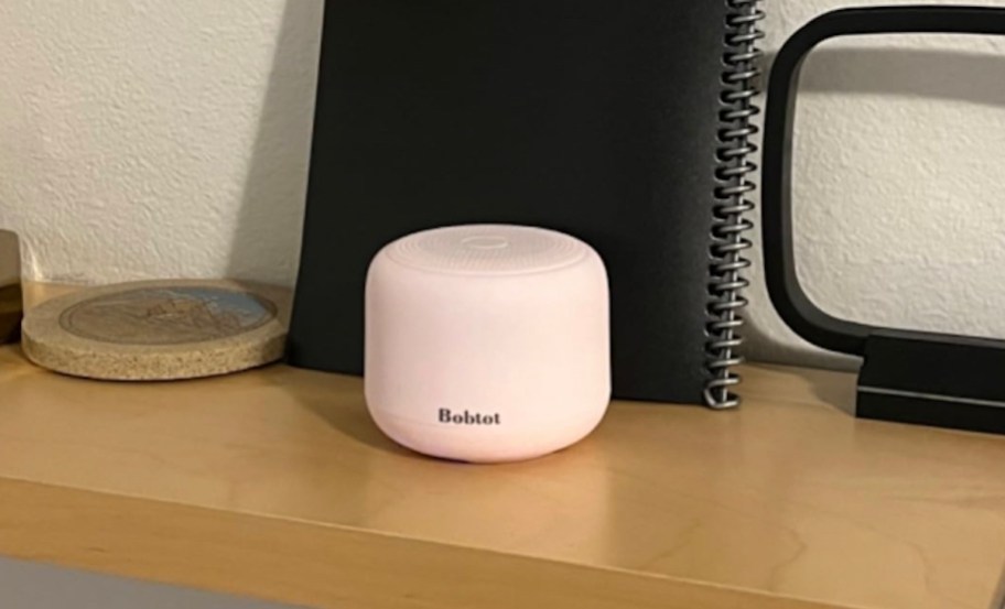 small light pink portable speaker on desk