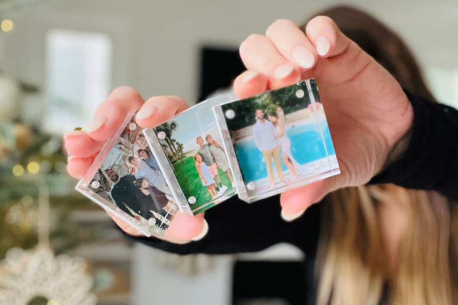 woman holding 3 acrylic photo blocks in front of face