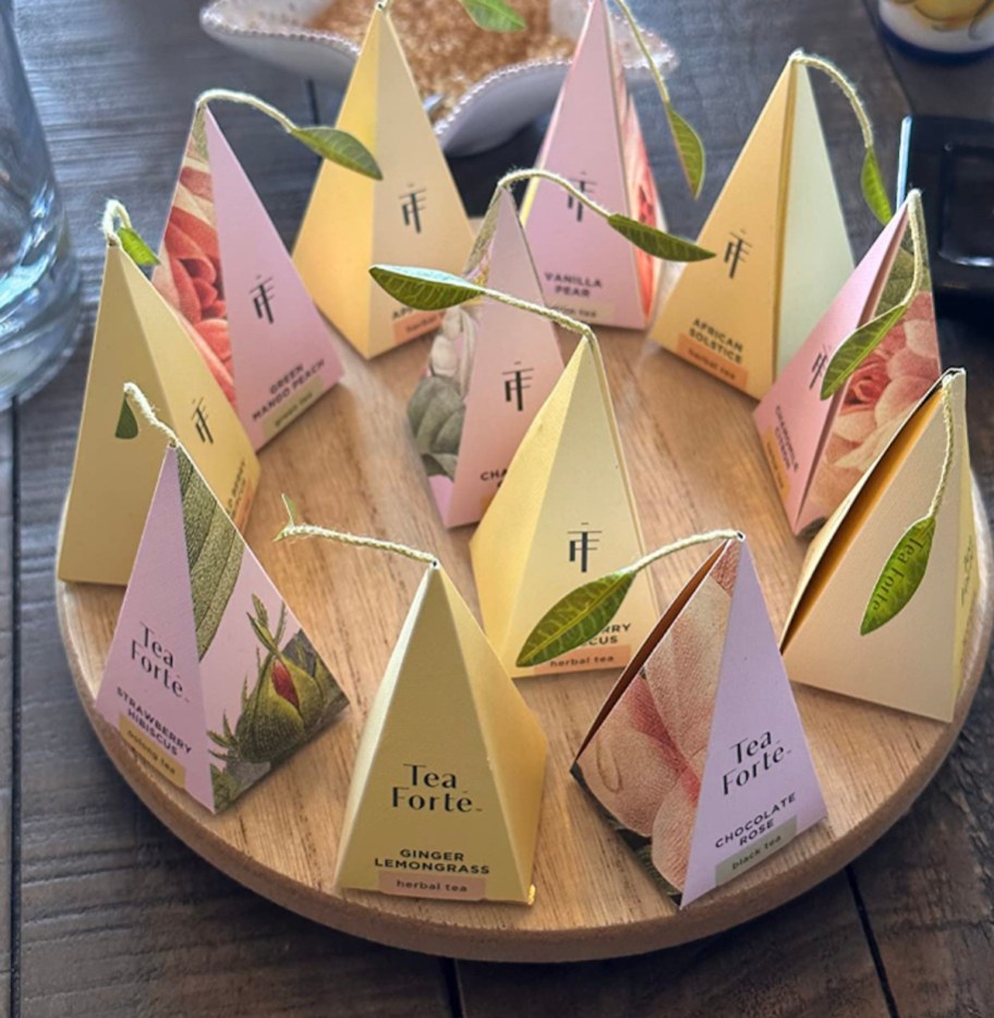 yellow and pink Tea Forte packages on wood serving board