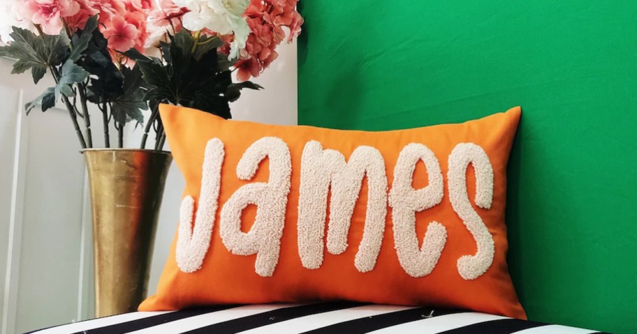 orange pillow that says james