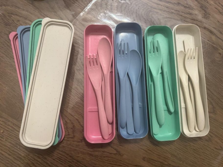 pink blue green and cream colored cutlery sitting in travel cases