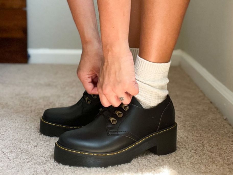 Woman tying her Dr. Martens shoes