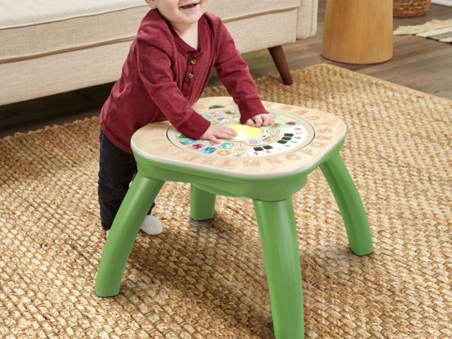 Toddler playing at a Leapfrog Wood Activity Table