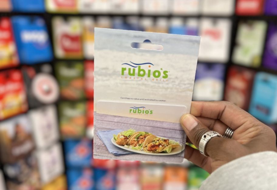 a womans hand holding a rubios gift card