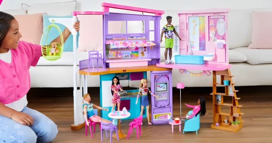 A girl playing with a Barbie Vacation House