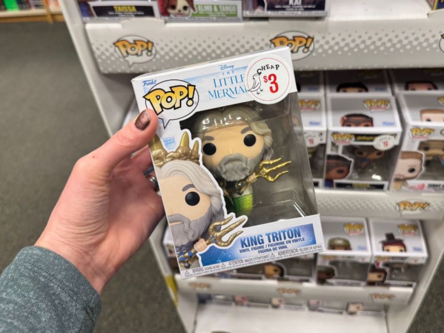 A person holding a Funko Pop! King Triton