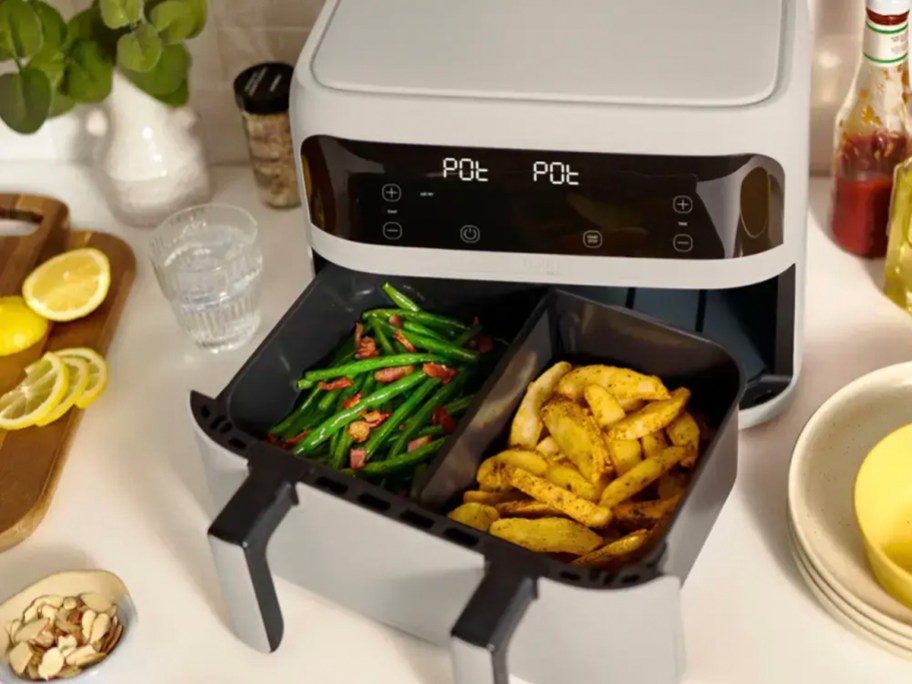 gray and black air fryer with potatoes and veggies inside 