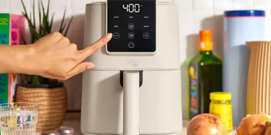 hand reaching for gray air fryer