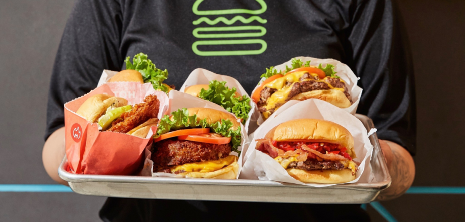 woman holding ray of hamburgers