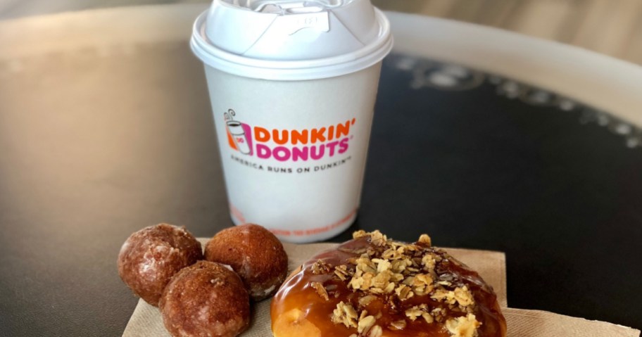 Dunkin Coffee on table next to donuts