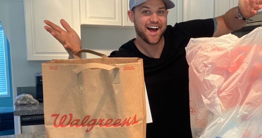 man standing next to a Walgreens bag