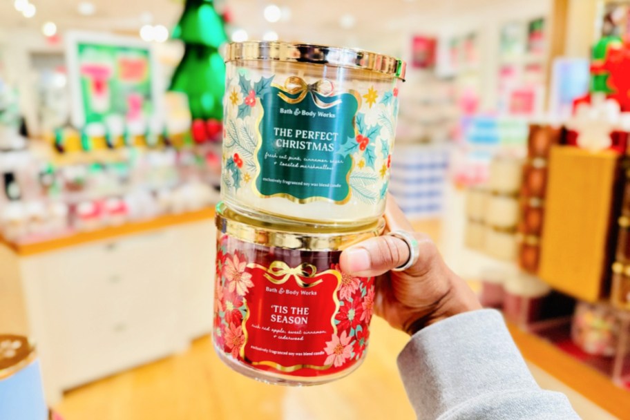 bath & body works christmas candles stacked in hand