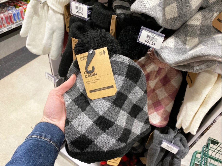 hand holding up a grey and black buffalo plaid beanie