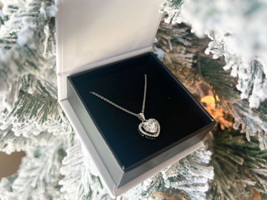 A Cate & Chloe Amora Hearts Shaped necklace in the gift box set on the branches of a Christmas tree