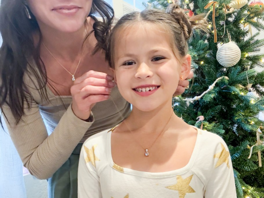 mom putting necklace on daughter