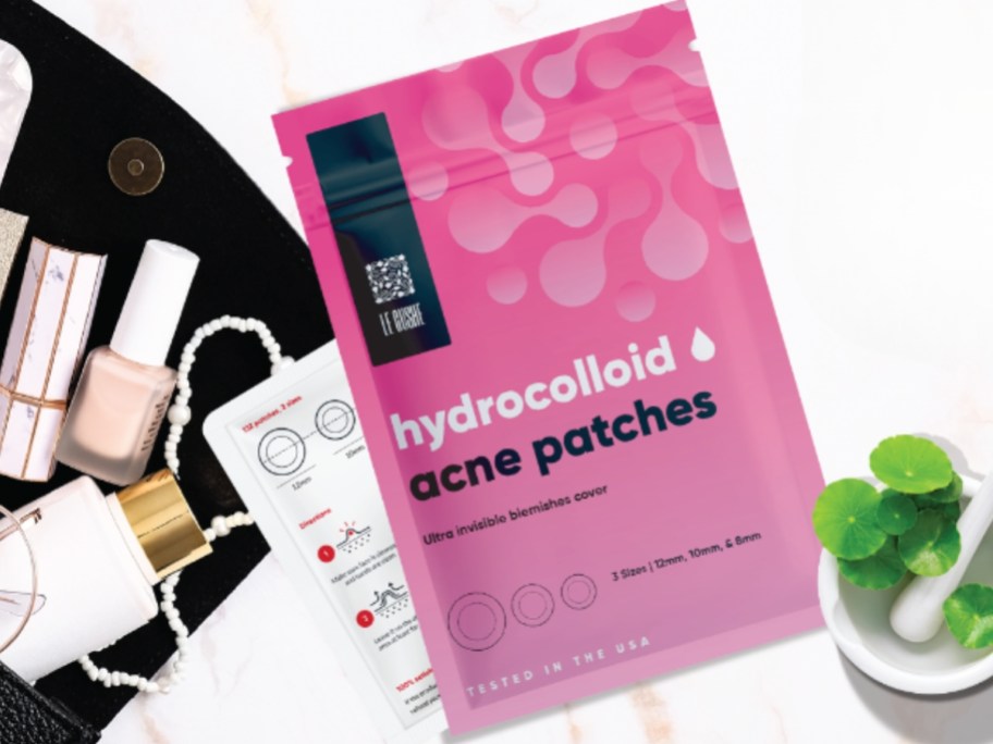 a pink package that says Le Gushe Hydrocolloid acne patches next to a purse with items spilling out