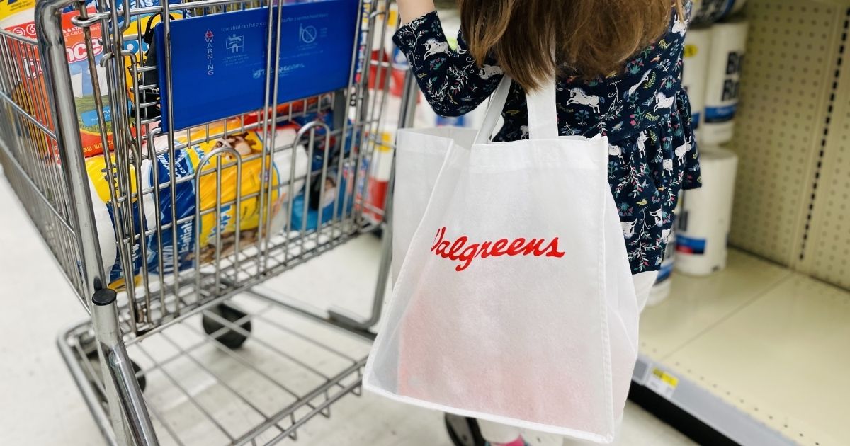 girl carrying a Walgreens bag and pushing a cart