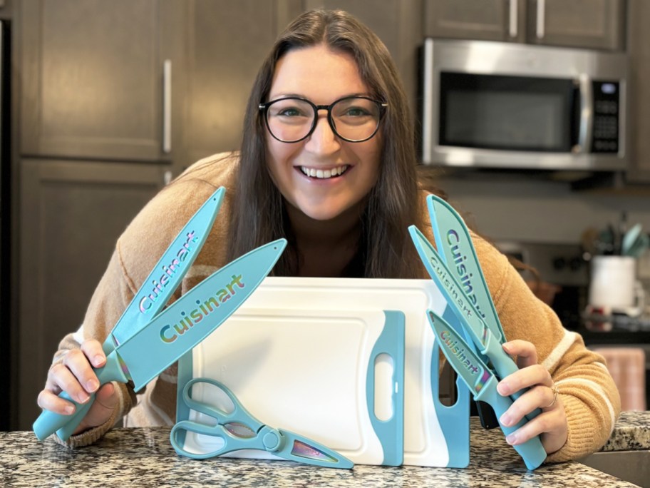 woman holding up teal kitchen knives with cutting board set