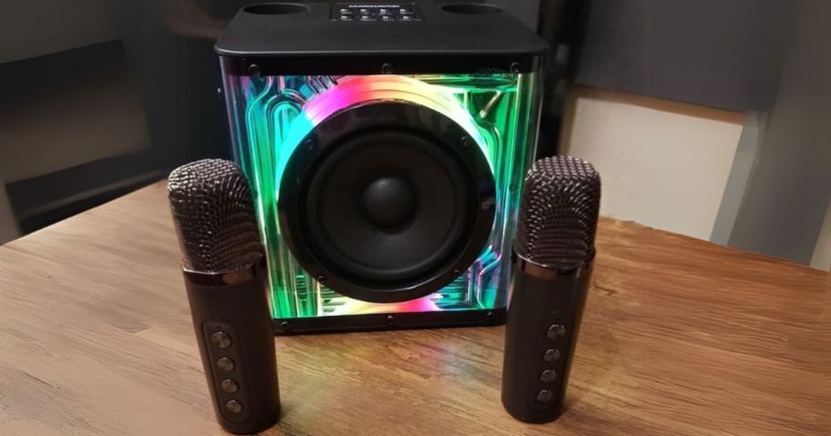 a small Karaoke machine with lights and 2 microphones on a table