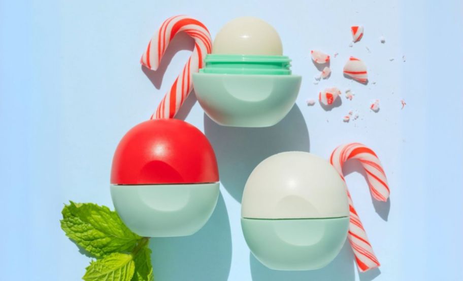 3 orbs of lip balm shown with mint leaves and crushed candy canes