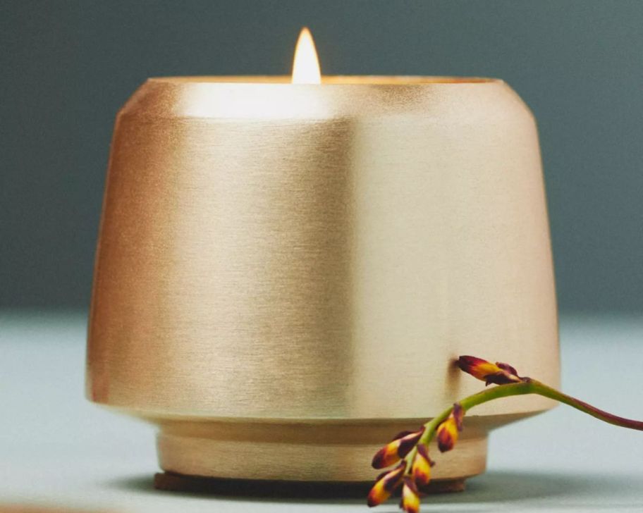 a gold candle shown lit