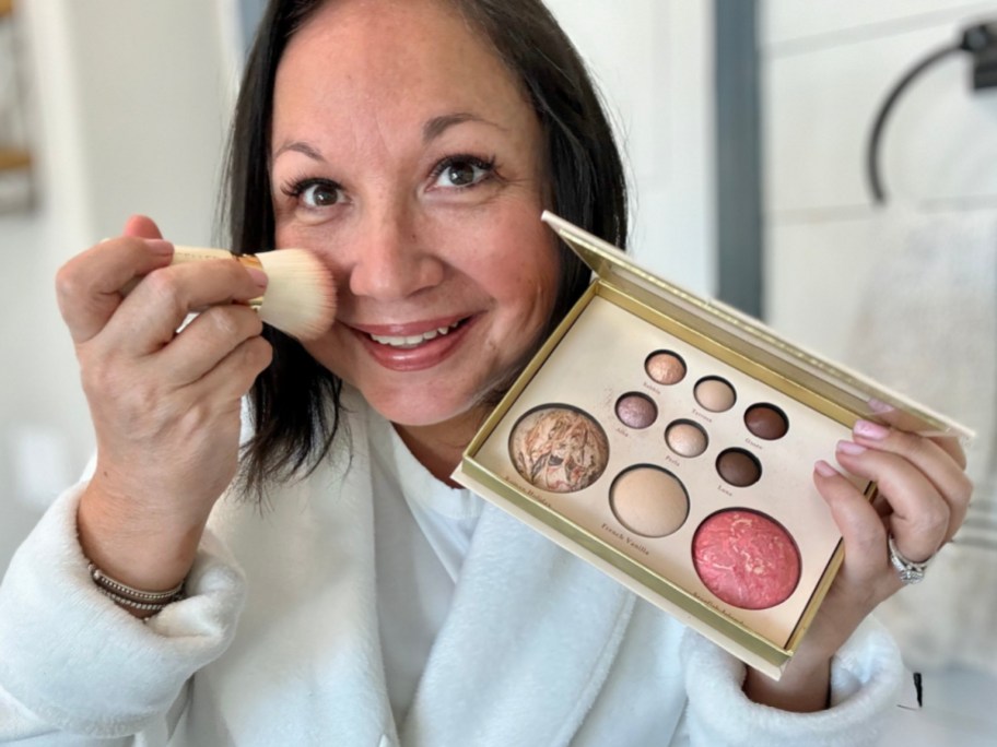 woman holding makeup palette near face