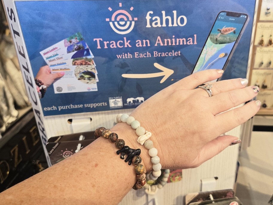 woman's arm wearing gorilla and penguin bracelets