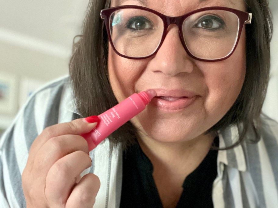 ina applying glowy lip balm