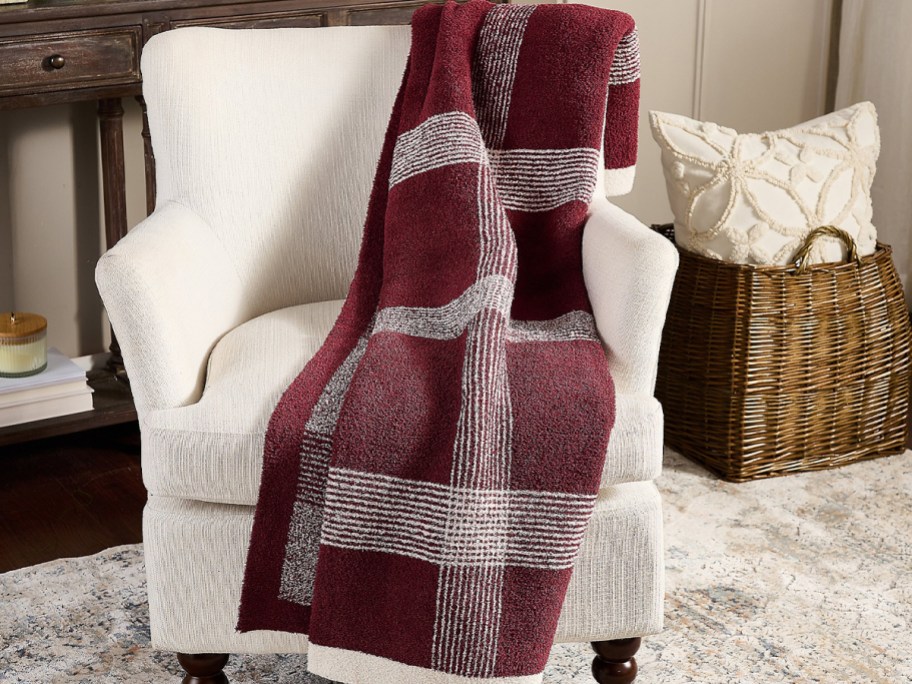 red and white plaid blanket laying on white chair 