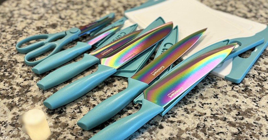 iridescent knife set with teal handles laid out on top of cutting board