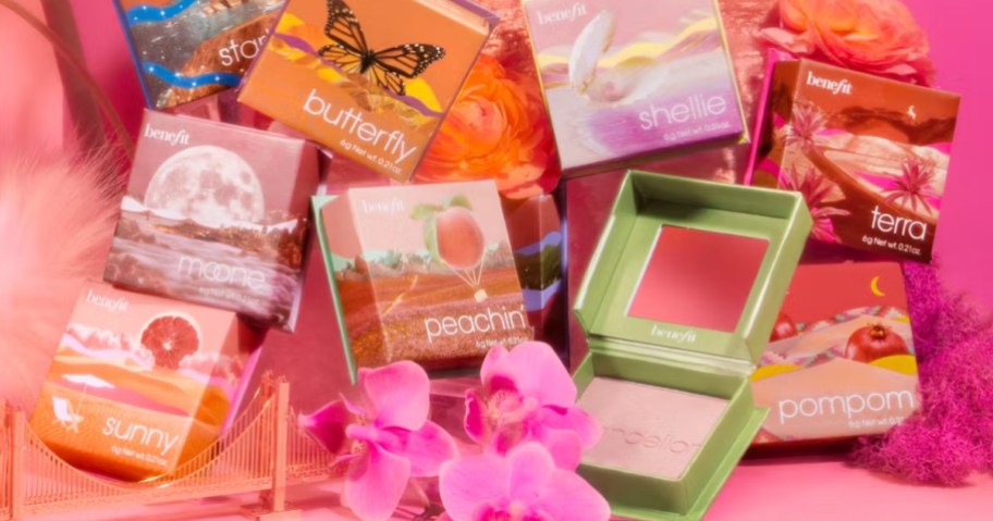 various boxes of Benefit Cosmetics 5-piece Silky Soft Powder Blush Set on a pink background with flowers