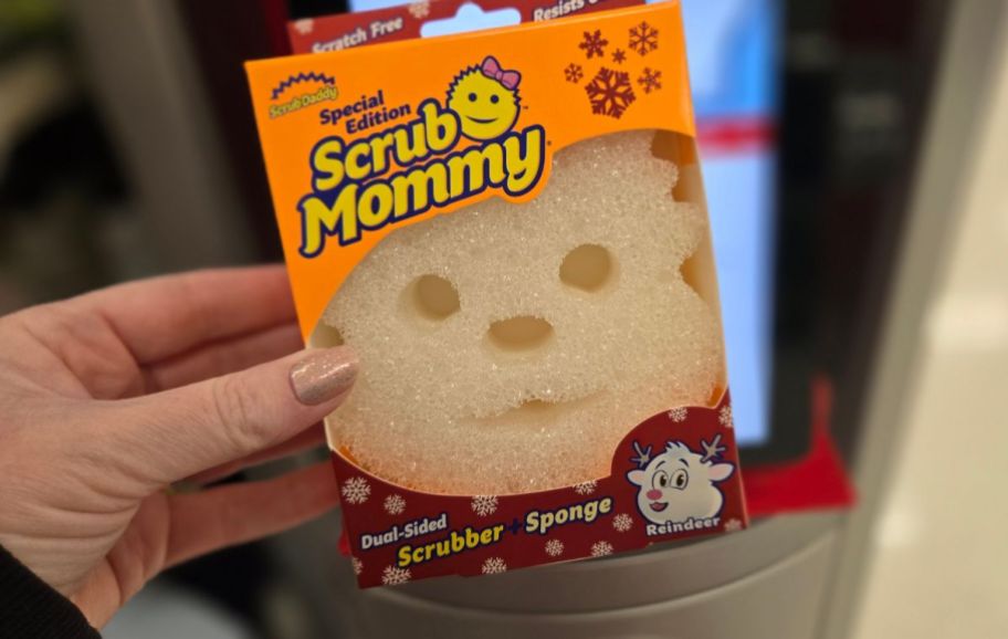 a womans hand holding a scrubdaddy sponge