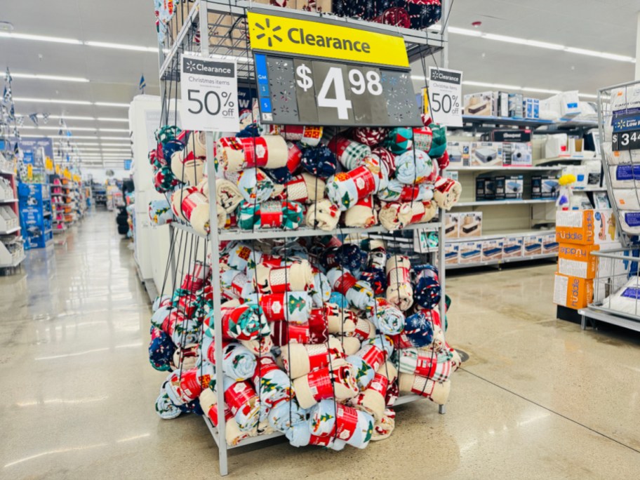 rack of holiday throw blankets on Christmas clearance at Walmart