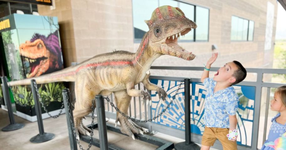 boy playing by fake Dinosaur