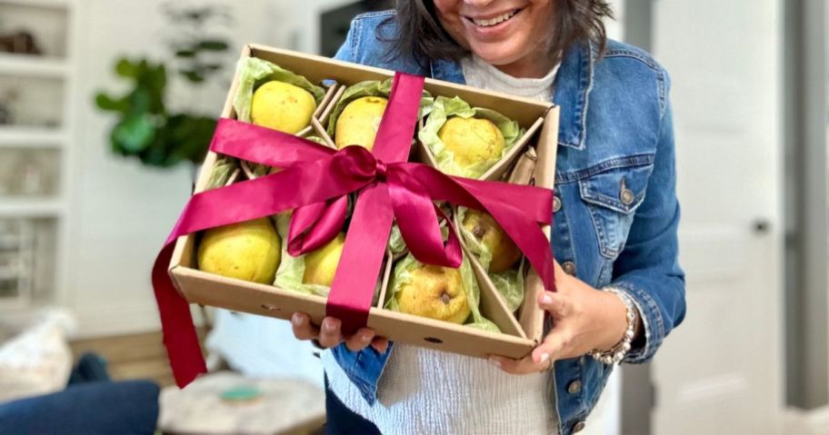 A woman holding a Harry & David Pears & Gift Box