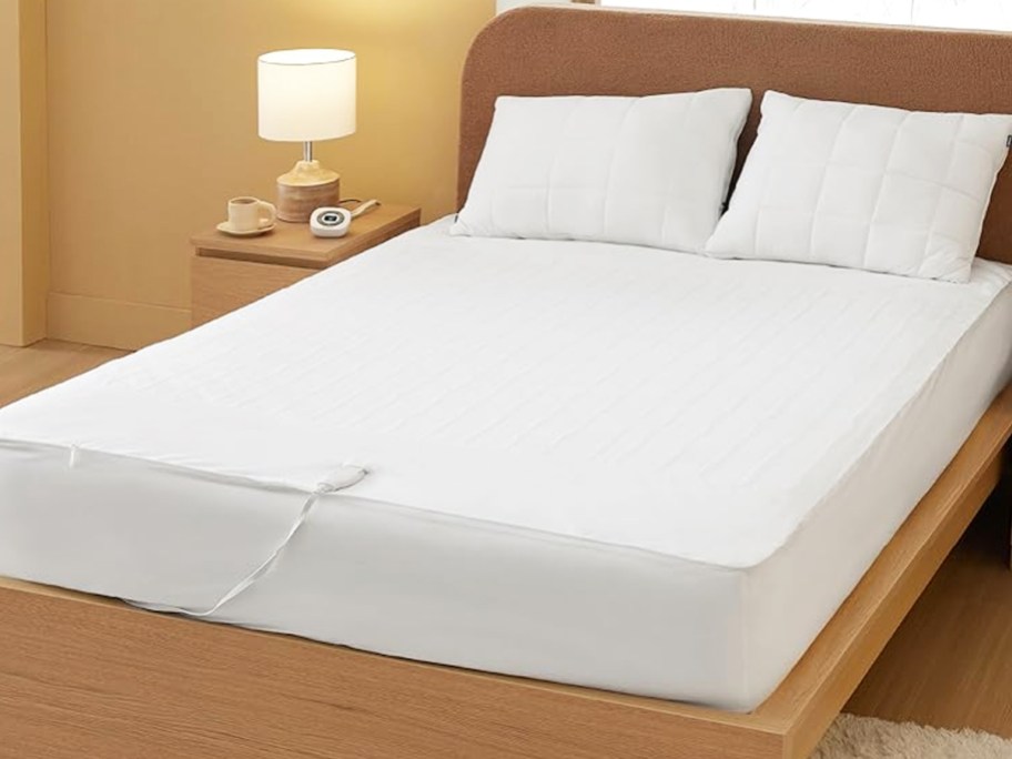 heated mattress pad on a bed with two white pillows