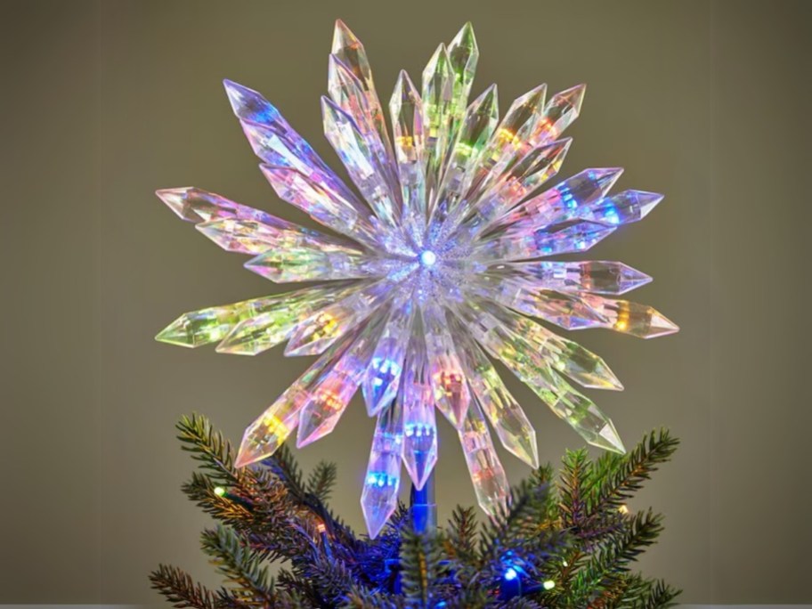 a colorful Christmas tree topper on top of a tree that looks like a multi point star