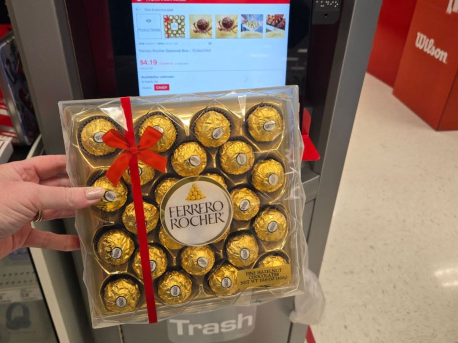 womans hand holding a 24count pack of hazlenut candy