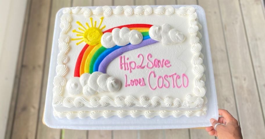 Costco sheet cake with a rainbow and "Hip2Save loves Costco" written in frosting