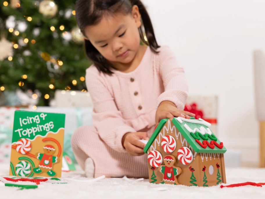 little girl playing with Melissa & Doug Gingerbread House Play Set