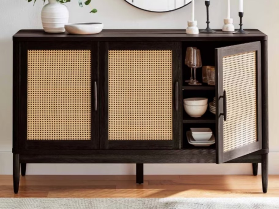 a sideboard buffet cabinet in black with light wood caning panels on the doors