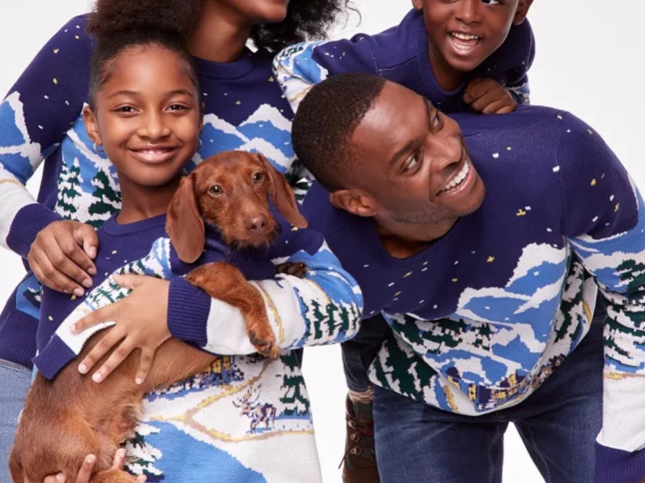 mom, dad, and kids wearing matching blue winter print Christmas sweaters