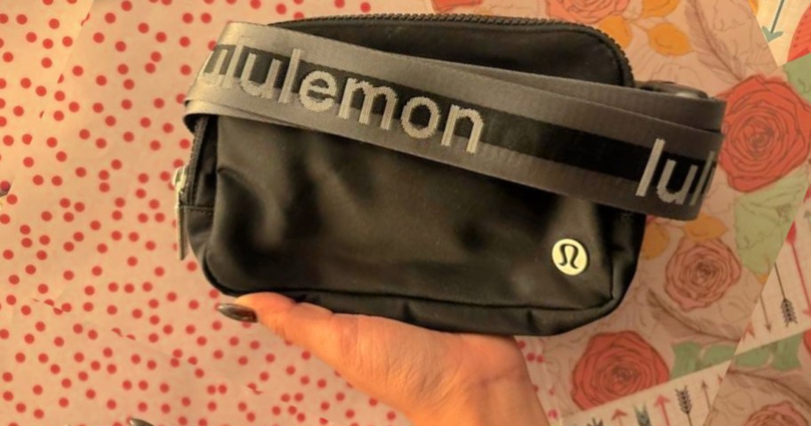 woman holding up black lululemon Wordmark Belt Bag