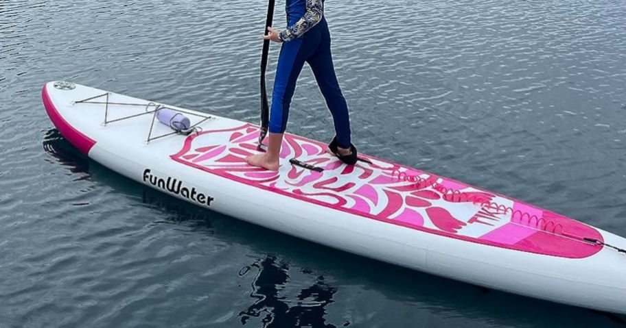 person standing on Inflatable Paddle Board - Classic Pink Totem