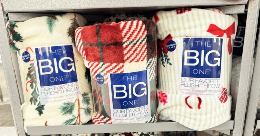 three christmas throw blankets on store display