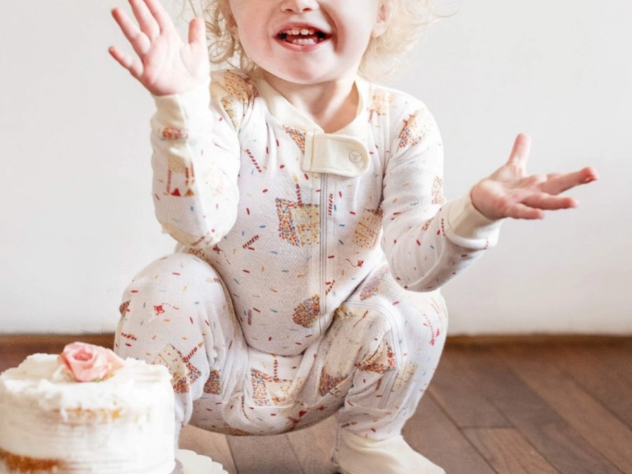 girl sitting next to cake in cake pjs