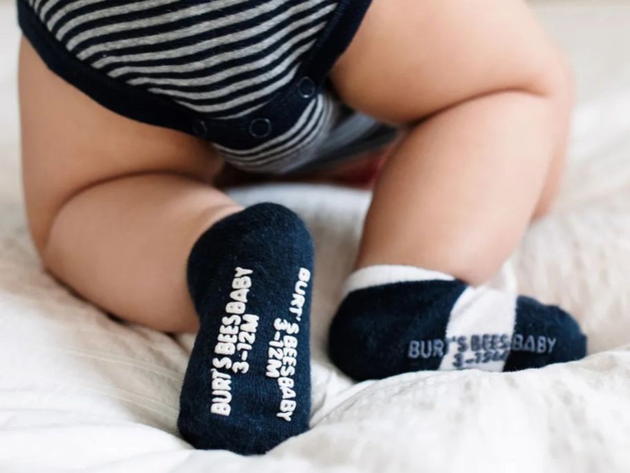 Backside view of a baby crawling wearing Burts Bees socks