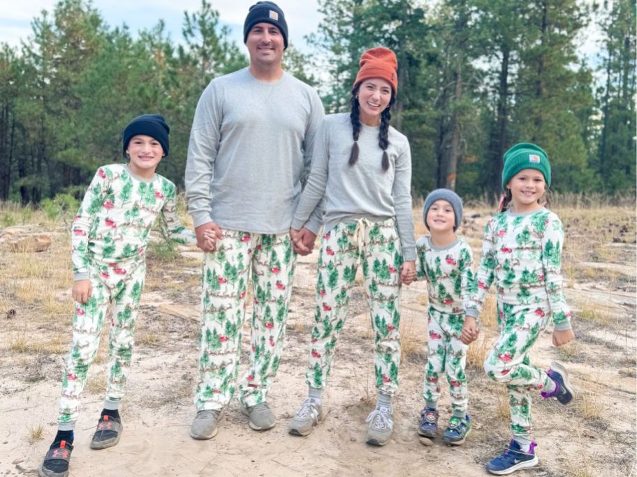 Family of 5 wearing Burts Bees Holiday pajamas outside with sneakers and beanies